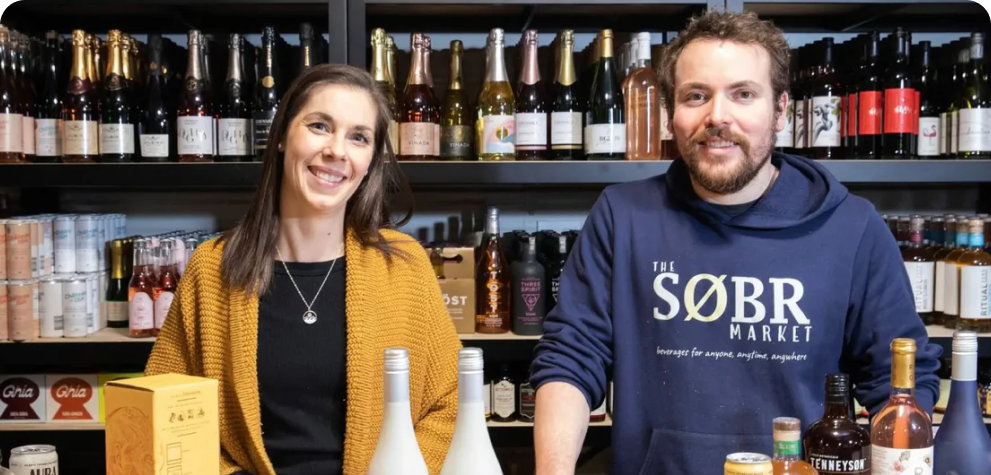 Man and woman stand behind the counter at Sobr Market